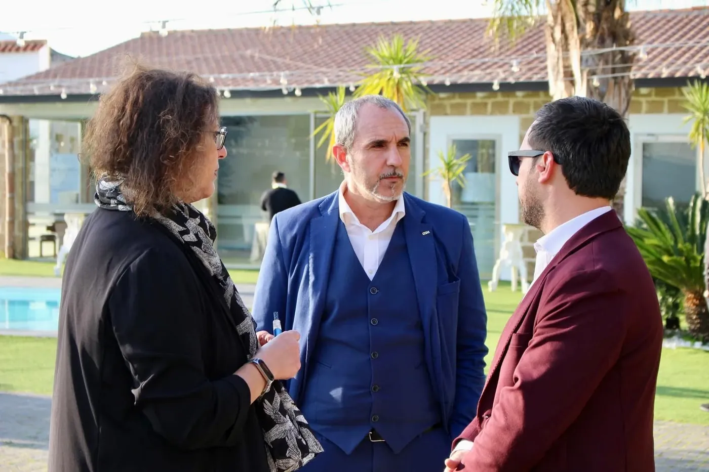 Giuseppe Zizza ascolta con attenzione due persone durante un incontro all’aperto