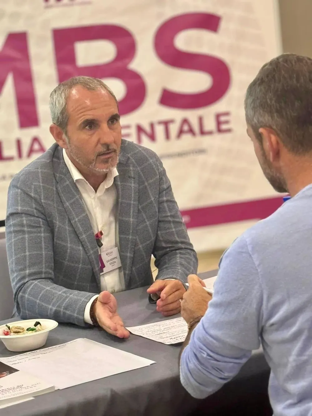 Giuseppe Zizza a un tavolo di confronto con un imprenditore, durante un evento
