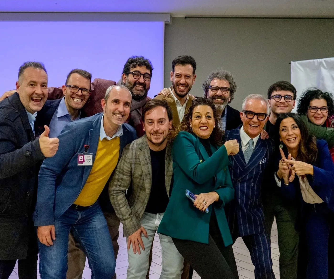 Giuseppe Zizza sorridente in un gruppo di colleghi durante un incontro OSM